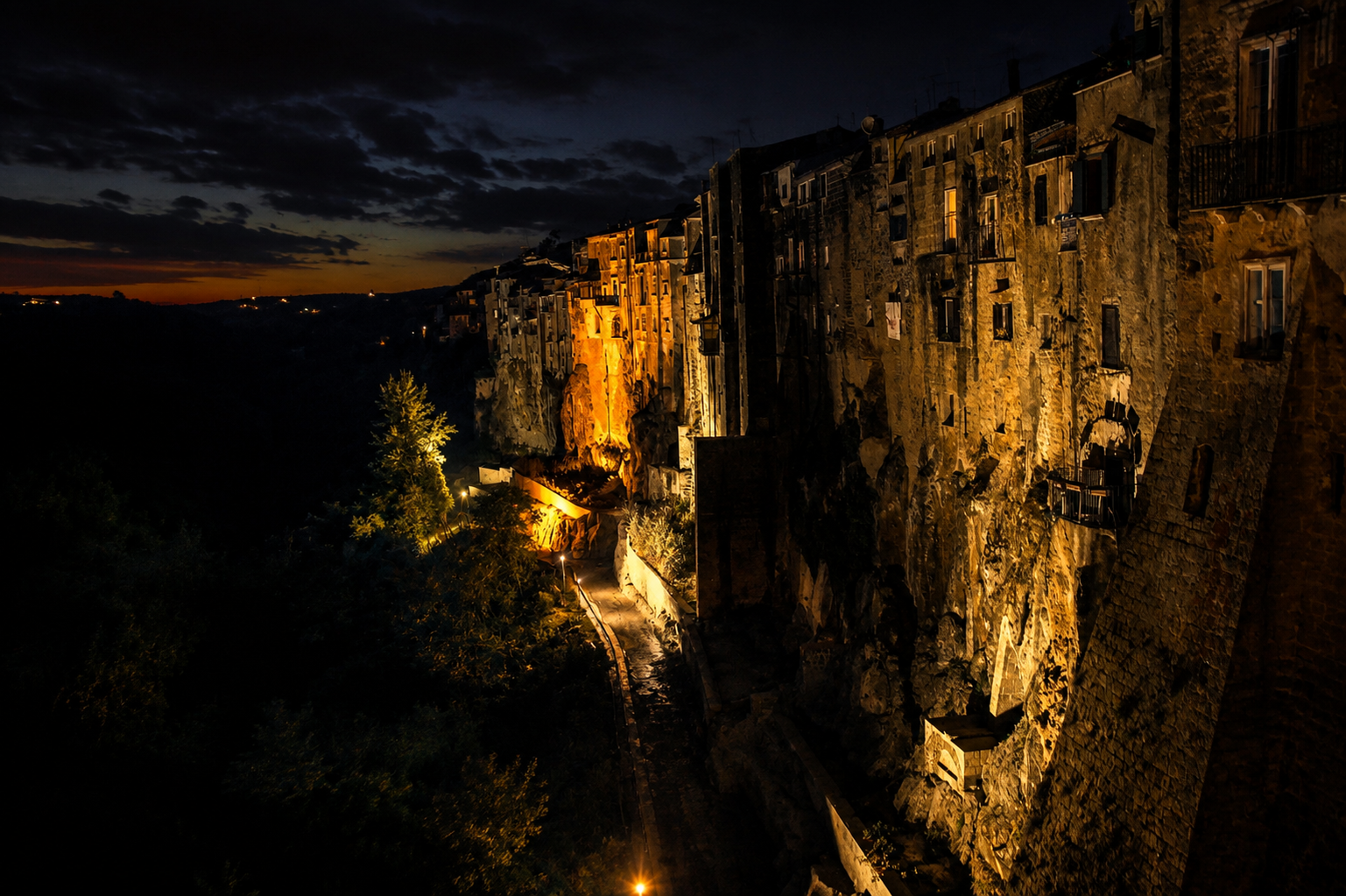 Sant'Agata de' Goti at night, with stone houses illuminated along the cliff
